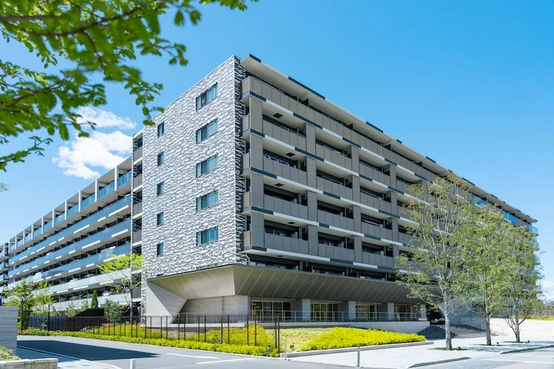 青空を背景にした大型マンションの外観